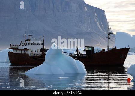 Chalutier de pêche au milieu des icebergs dans le port d'Uummannaq dans le fjord d'Uummannaq, Groenland, Danemark Banque D'Images