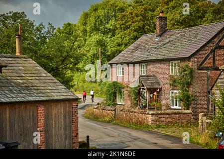 Village de Chelford et paroisse civile à Cheshire, Angleterre, campagne autour du village une ferme avec des cyclistes passant Banque D'Images