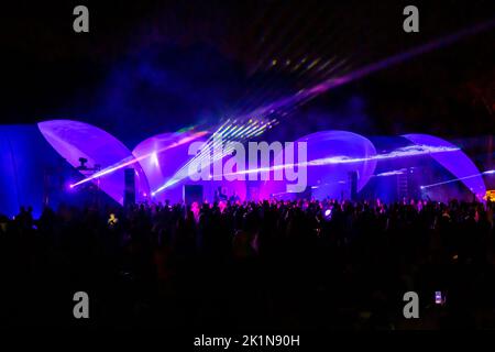 Des lumières laser colorées brillent et se déplacent sur la foule dansante pendant la fête du DJ Banque D'Images