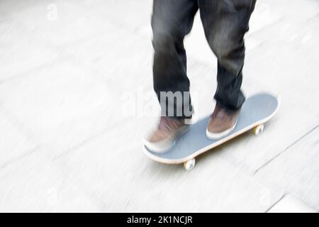 Skateboarder essayant de flip-trick dans un haut spee dans un skatepark dans la ville Banque D'Images