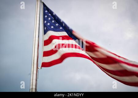 Le drapeau américain fait un vagues dans la brise devant un ciel couvert en fin d'après-midi à Washington, D.C., en juillet 2022 Banque D'Images