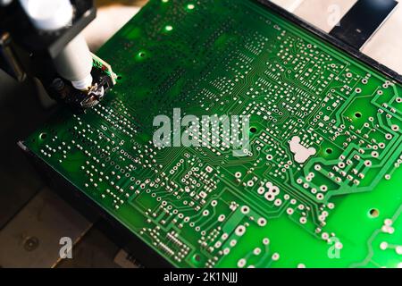 Manipulateur automatique avec aiguille distribuant la pâte à souder sur la carte de circuit imprimé de l'ordinateur CMS. Photo de haute qualité Banque D'Images