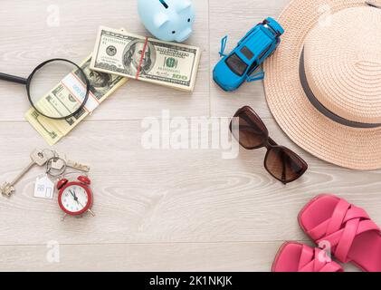 Une banque de cochon avec des billets de dollars dans un cadre de voyage. Dans la composition de l'image: Sun Hat, réveil. Concept d'économie d'argent pour les voyages Banque D'Images