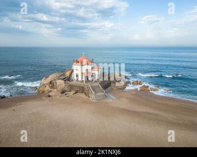 Vue aérienne de l'église Senhor da Pedra, au milieu de la plage et de l'océan à Miramar, Portugal Banque D'Images