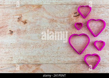 Heart shaped fried egg blocks on wooden background. Stock Photo