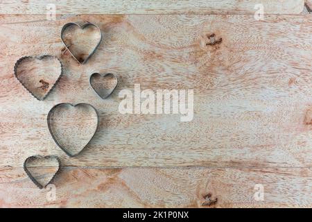 Heart shaped fried egg blocks on wooden background. Stock Photo