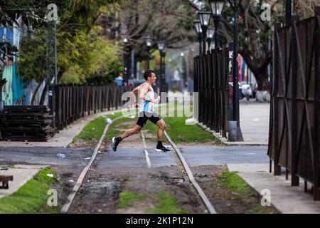 Buenos Aires, Argentine. 18th septembre 2022. Un coureur d'élite traverse quelques voies ferrées dans le quartier de Buenos Aires, la Boca. Neuf mille personnes ont rempli les rues de la ville pendant le Marathon de Buenos Aires de 42K. La concurrence internationale a retrouvé toute sa splendeur avec plus de 1 600 coureurs étrangers, dont beaucoup du Brésil, de l'Uruguay et du Chili. Crédit : SOPA Images Limited/Alamy Live News Banque D'Images