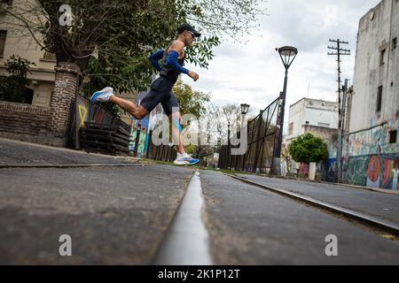 Buenos Aires, Argentine. 18th septembre 2022. Un coureur d'élite traverse quelques voies ferrées dans le quartier de Buenos Aires, la Boca. Neuf mille personnes ont rempli les rues de la ville pendant le Marathon de Buenos Aires de 42K. La concurrence internationale a retrouvé toute sa splendeur avec plus de 1 600 coureurs étrangers, dont beaucoup du Brésil, de l'Uruguay et du Chili. Crédit : SOPA Images Limited/Alamy Live News Banque D'Images