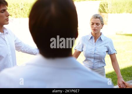 Restez calme et continuez. Un groupe de collègues méditant pendant une retraite d'affaires. Banque D'Images