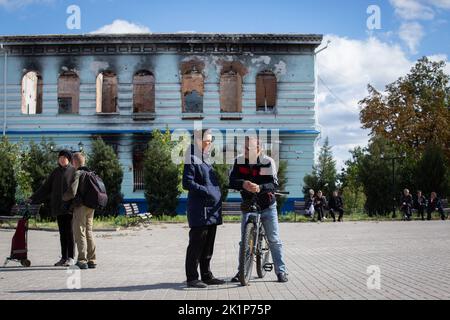 Izium, Ukraine. 19th septembre 2022. Les locaux communiquent devant les bâtiments détruits dans la ville d'Izium, récemment libérée par les forces armées ukrainiennes, dans la région de Kharkiv. La ville d'Izium a été occupée par des troupes russes sur 1 avril 2022. Crédit : SOPA Images Limited/Alamy Live News Banque D'Images