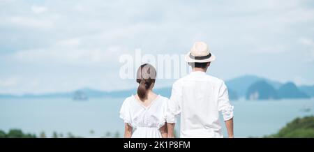 Joyeux couple voyageur en chemise blanche et robe profiter de la belle vue, les touristes avec debout et se détendre sur l'océan. Voyage, ensemble, amour, été an Banque D'Images