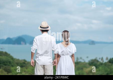 Joyeux couple voyageur en chemise blanche et robe profiter de la belle vue, les touristes avec debout et se détendre sur l'océan. Voyage, ensemble, amour, été an Banque D'Images