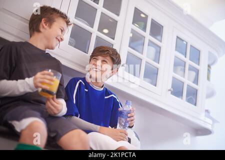 Frères et amis. Deux jeunes garçons qui ont des boissons froides après la pratique du football Banque D'Images