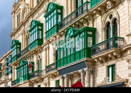 Partie de la façade du bâtiment avec des balcons traditionnels en bois ornés peints en vert à la Valette, Malte. Banque D'Images