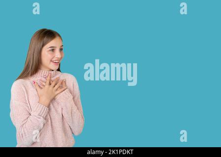 Fille impressionnée. Contexte publicitaire. Surprise de vacances. Offre spéciale. Portrait d'une jeune femme excitée et heureuse qui regarde le produit invisible smil Banque D'Images