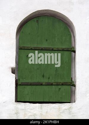 Petite porte en bois vert dans l'ancien mur blanc Banque D'Images