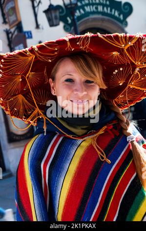 Lieu de rencontre du vieux monde Jama Michakika à Kraków, Pologne et une longue tresse blonde et cape serape polonaise. Banque D'Images