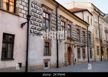 Renaissance Kanonicza Street à Cracovie, Pologne et une grande porte voûtée en pierre avec entablature élaborée. Banque D'Images