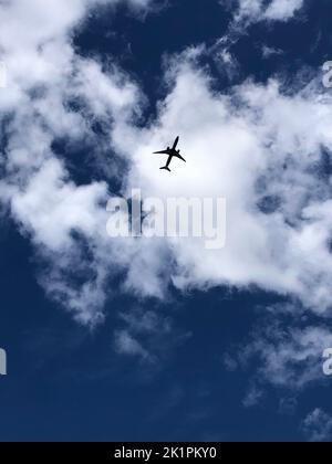 Vue à angle bas d'un avion passager volant à basse altitude avec les nuages en arrière-plan Banque D'Images