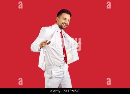 Bon homme de race blanche dansant en costume sur fond de studio Banque D'Images