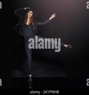 Il a fait un bruit de frappe. Plein studio de prise de vue d'une femme qui frappe avec un fond noir Banque D'Images