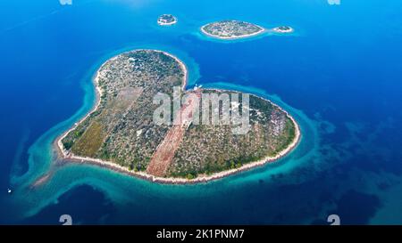 Une photo aérienne de l'île de Galesnjak en forme de coeur entourée d'eau bleu vif en Croatie Banque D'Images