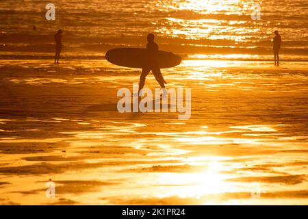 Wednesday 10 August 2022 - Newquay, Cornwall, UK; A Surfer is seen making the most of the golden sun on Fistral Beach in Newquay as Boardmasters Festi Stock Photo