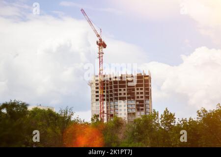 Grue de construction en rayons de soleil. Maison en construction et grue. Banque D'Images