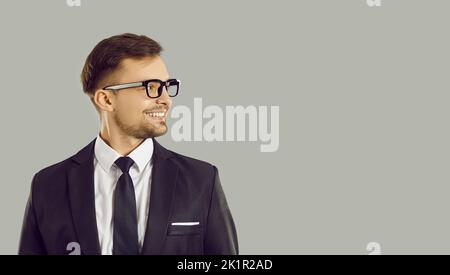 Un jeune homme d'affaires confiant, amical et réussi qui regarde l'espace de copie sur fond gris clair. Banque D'Images