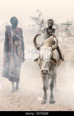 Un petit garçon à la vache. Soudan du Sud : CES IMAGES ÉPOUSTOUFLANTES montrent l'incroyable lien entre le peuple Mundari et son bétail au Soudan du Sud. O Banque D'Images