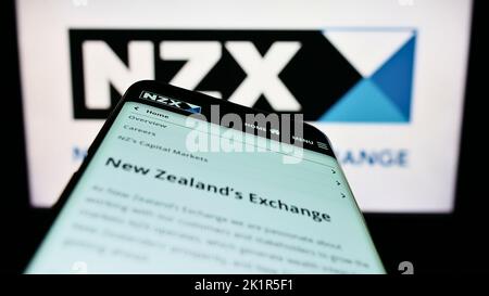 Smartphone avec page Web de la société financière New Zealand's Exchange (NZX) à l'écran devant le logo. Faites la mise au point dans le coin supérieur gauche de l'écran du téléphone. Banque D'Images