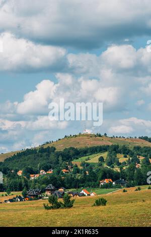 Magnifique paysage pittoresque de la région de Zlatibor avec des maisons de style architectural distinctives dispersées sur des collines verdoyantes le jour d'été ensoleillé Banque D'Images