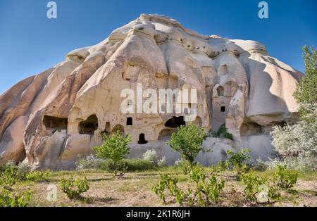 Maisons en pierre sculptée ou maisons de grotte dans le paysage de la vallée de la Rose Goreme, Cappadoce, Anatolie, Turquie Banque D'Images