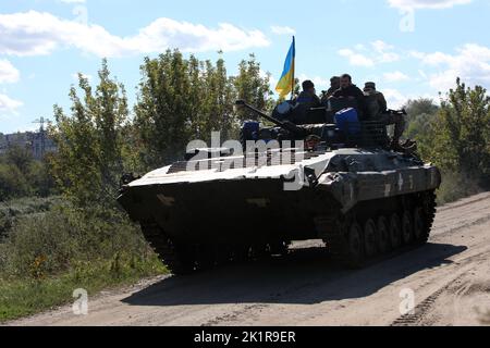 IZIUM, UKRAINE - 19 SEPTEMBRE 2022 - des militaires ukrainiens se trouvent au-dessus d'un véhicule militaire à Izium, libéré des envahisseurs russes de la région de Kharkiv Banque D'Images