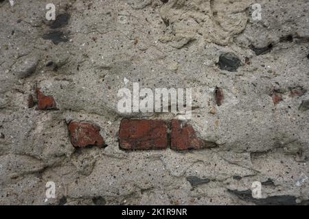 plastered old wall detail, red brick in between Stock Photo