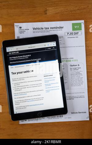 Formulaire V11 Avis de rappel de taxe sur les véhicules de l'Agence de permis de conduire et de véhicules. Avec le site Web DVLA affiché sur un ipad. Banque D'Images