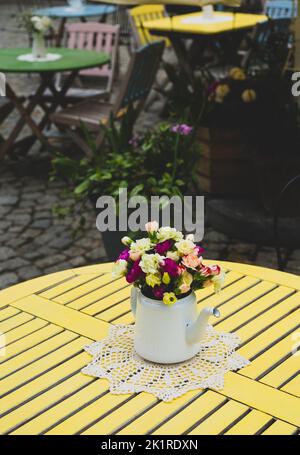 Inflorescence de roses colorées fleurs dans la théière sur la table, vieille ville de Lublin Banque D'Images