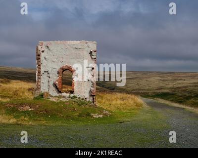 L'arrivée de l'automne dans le Yorkshire - un chemin de courbure passait par un mur mystérieux et solitaire d'une structure en ruines et à travers des landes accidentées, automnales et ensoleillées. Banque D'Images