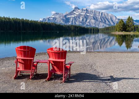 Deux lacs Jack avec les chaises rouges iconiques adirondack sur le rivage du parc national Banff Banque D'Images