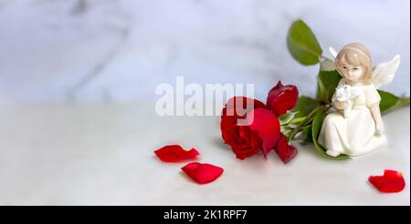 Bannière. Ange mignon avec une rose rouge sur fond de marbre blanc. Le thème de l'amour. la saint-valentin. Une carte postale pour les vacances. Bonne journée ange. Mer Banque D'Images