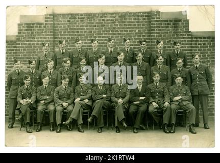 Original WW2 Era Royal Air Force personnel (RAF) aviateurs portant l'uniforme de tunique et les casquettes latérales. À l'école de formation aérienne. Il y a des examinateurs ou du personnel non militaire, des stylos dans les poches assis avec eux. Vers 1943, lieu inconnu, Royaume-Uni Banque D'Images