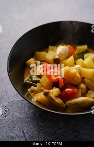 Curry thaï rouge avec chou-fleur, haricots verts, champignons et pommes de terre Banque D'Images