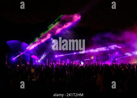 Des lumières laser colorées brillent et se déplacent sur la foule dansante pendant la fête du DJ Banque D'Images