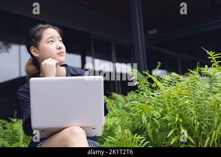 smart est asiatique jeune nouvelle génération de femmes d'affaires de penser projets créatifs en plein air avec ordinateur portable Banque D'Images