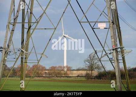 looking through electricity pylon to wind turbine selby yorkshire united kingdom Stock Photo