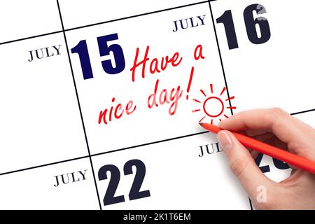 15th jour de juillet. La main écrivant le texte ont une belle journée et dessinant le soleil sur la date calendrier 15 juillet. Enregistrez la date. Mois d'été, jour du Banque D'Images