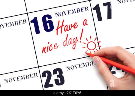 16th jour de novembre. La main écrivant le texte ont une belle journée et dessinant le soleil sur la date calendrier 16 novembre. Enregistrez la date. Automne mois, jour Banque D'Images