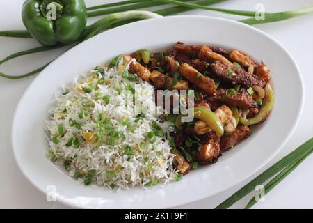 Panner maïs de bébé Manchurien. Un plat végétarien indo chinois croustillant et croustillant, dans une sauce douce avec des poivrons sautés et des oignons. Prise de vue sur b blanc Banque D'Images