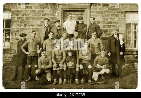 Original, clair début des années 1900, carte postale de l'équipe de football et des supporters qui portent des casquettes plates, posant pour une photo à l'extérieur d'un pub. Un jeune lad est assis à l'avant, tenant un ballon de football marqué par 'E.R. ET S. AFC, 1911-1912', U.K. Banque D'Images