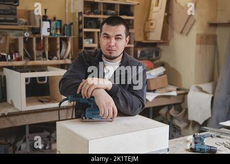 Portrait d'un homme confiant regardant l'appareil photo tout en étant debout dans un atelier de travail du bois, espace de copie Banque D'Images